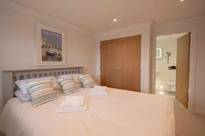 a bedroom with a white bed with towels on it at Chy An Gweal Farm Coach House in Carbis Bay