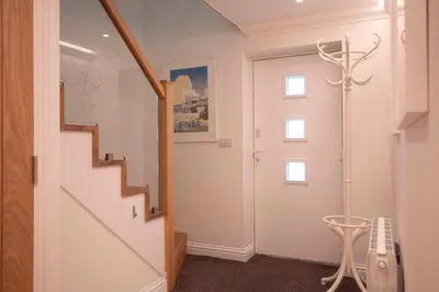 a hallway with a stairway with a door and a stair at Chy An Gweal Farm Coach House in Carbis Bay