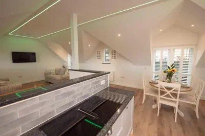 a kitchen with a stove top oven next to a table at Chy An Gweal Farm Coach House in Carbis Bay