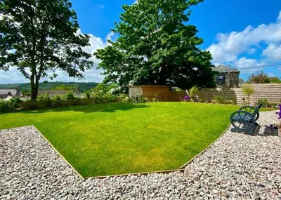 a yard with a bench in the grass at double room in Wadebridge