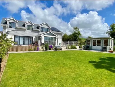 a large white house with a large yard at double room in Wadebridge