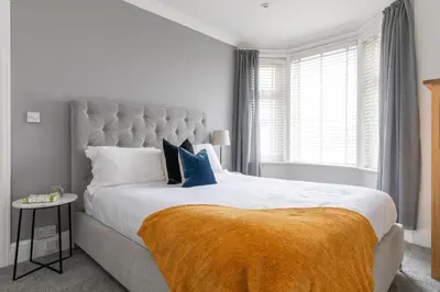 a bedroom with a large bed with a large window at Beachwalk in Newquay