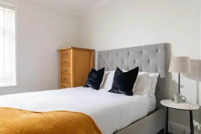 a bedroom with a large white bed with black pillows at Beachwalk in Newquay