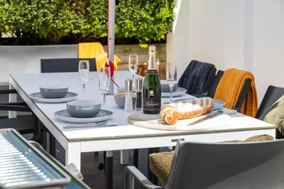 a white table with glasses and a bottle of wine at Beachwalk in Newquay