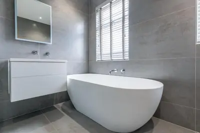 a white bath tub in a bathroom with a window at Beachwalk in Newquay