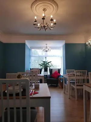 a dining room with tables and chairs and a chandelier at Chandler's Lodge B&B in Camelford