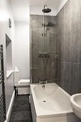 a bathroom with a bath tub and a sink at Chandler's Lodge B&B in Camelford