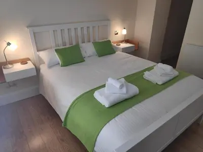 a white bed with green and white towels on it at Chandler's Lodge B&B in Camelford