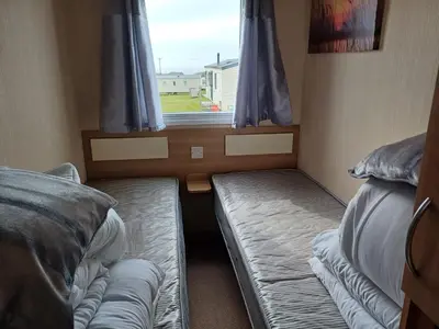 a small room with two beds and a window at 20 in Trelaske