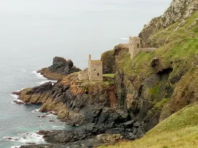 a castle on a cliff next to the ocean at Malvern Cottage in Perranporth