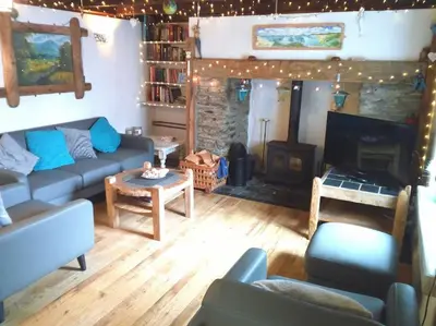 a living room with a couch and a fireplace at Malvern Cottage in Perranporth
