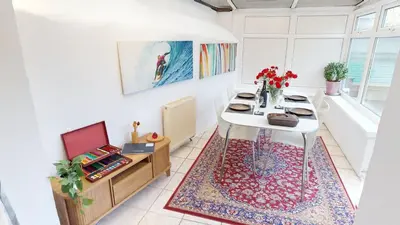 a dining room with a white table with flowers on it at St Ives The Villa in St Ives