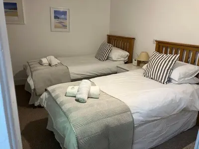 a bedroom with two beds with towels on them at St Ives The Villa in St Ives