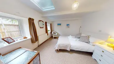 a bedroom with a white bed and a window at St Ives The Villa in St Ives