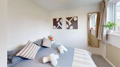 a bedroom with a bed with pillows and a mirror at St Ives The Villa in St Ives