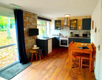 a kitchen with a table and a dining room at Painters Cottage 2-Bed Chalet nr St Ives & Hayle in St Ives