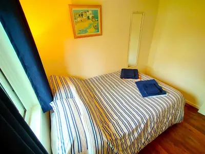 a bedroom with a bed with two blue towels on it at Painters Cottage 2-Bed Chalet nr St Ives & Hayle in St Ives