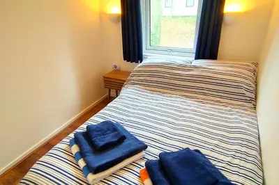 two beds in a room with towels on them at Painters Cottage 2-Bed Chalet nr St Ives & Hayle in St Ives