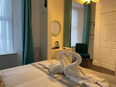 two swans towels are sitting on a bed at Tintagel Arms Bed and Breakfast in Tintagel