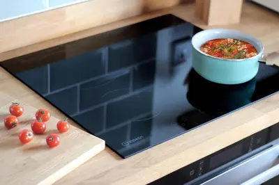 a bowl of soup sitting on top of a stove with tomatoes at Scandi Cabin On A Hill, With Stunning Views Across Cornwall in Nancledra