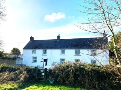 a white house sitting on top of a green field at 3 Bed in Newquay oc-82369 in Mitchell