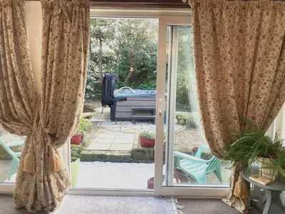 an open sliding glass door with a view of a garden at 2 Bed in Newquay oc-82370 in Mitchell
