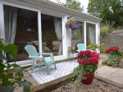 a porch with two blue chairs and flowers at 2 Bed in Newquay oc-82370 in Mitchell