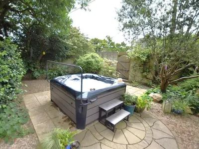 a hot tub in a garden with a set of steps at 2 Bed in Newquay oc-82370 in Mitchell