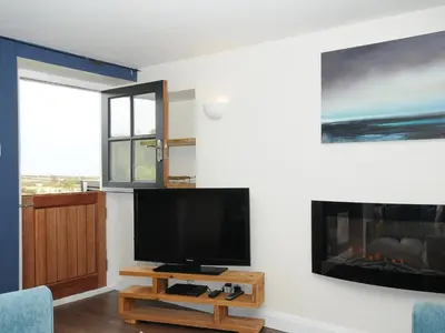 a living room with a tv and a fireplace at The Bower in Helston