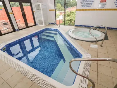 a swimming pool and a tub in a building at Breeze Cottage in Falmouth