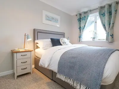 a bedroom with a bed and a window at Breeze Cottage in Falmouth
