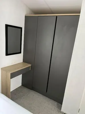 a bedroom with a closet with a mirror and a shelf at The Cornish hottub escape in St Austell