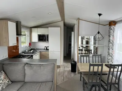 a kitchen and living room with a table and chairs at The Cornish hottub escape in St Austell