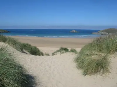 a sandy beach with the ocean in the background at Sunny Corner - Coastal apartment near the beach in Crantock