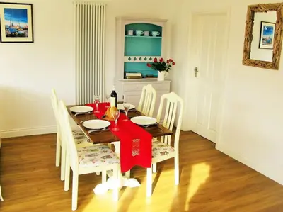 a dining room with a table with a red napkin on it at Sunny Corner - Coastal apartment near the beach in Crantock