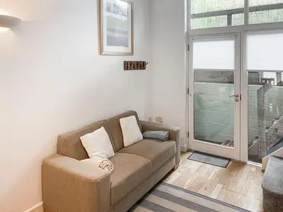 a living room with a couch and a window at Trebellan in Porthtowan