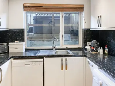 a kitchen with a sink and a window at Trebellan in Porthtowan