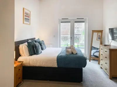 a bedroom with a bed with a teddy bear on it at Trebellan in Porthtowan