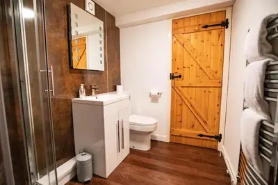 a bathroom with a toilet and a sink and a door at Treworgie Barton - Duchy in Bude
