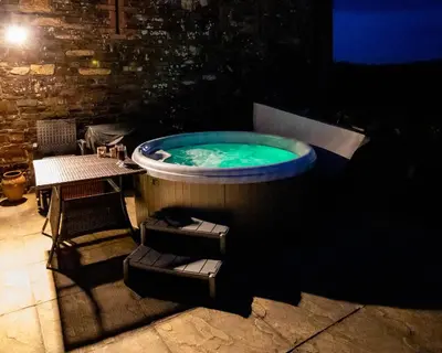 a jacuzzi tub in a room with a table at Treworgie Barton - Duchy in Bude