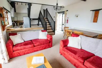 a living room with two red couches and a table at Treworgie Barton - Duchy in Bude