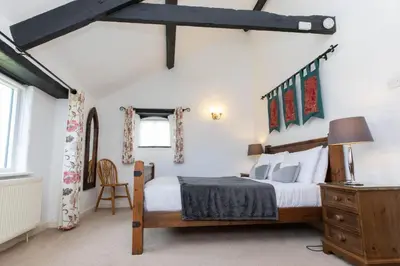 a bedroom with a bed and a dresser in a room at Treworgie Barton - Butterwell in Bude