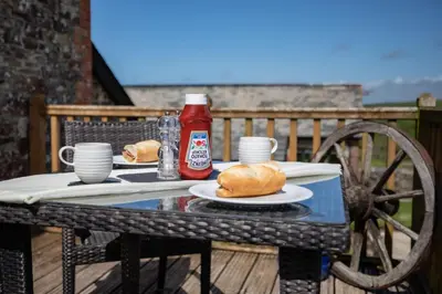 a table with two plates of food and ketchup at Treworgie Barton - Butterwell in Bude