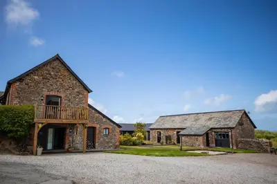 an old stone house with a deck on a driveway at Treworgie Barton - Butterwell in Bude