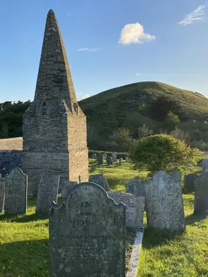 a grave yard with a hill in the background at Bryher in Wadebridge