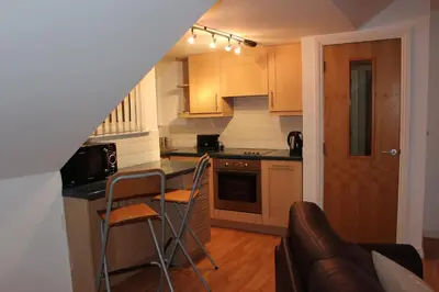 a kitchen with a counter and two chairs in it at Bryher in Wadebridge