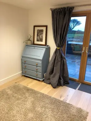 a blue dresser in a room with a window at Apple Tree Barn - converted barn with meadow views in Helston
