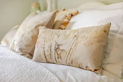 a bed with white pillows with a deer on it at 3 Bed in Germoe oc-w29163 in Germoe