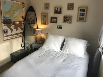a bedroom with a bed and a surfboard on the wall at No 63 Atlantic reach in Newquay