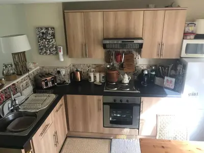 a kitchen with wooden cabinets and a stove top oven at No 63 Atlantic reach in Newquay